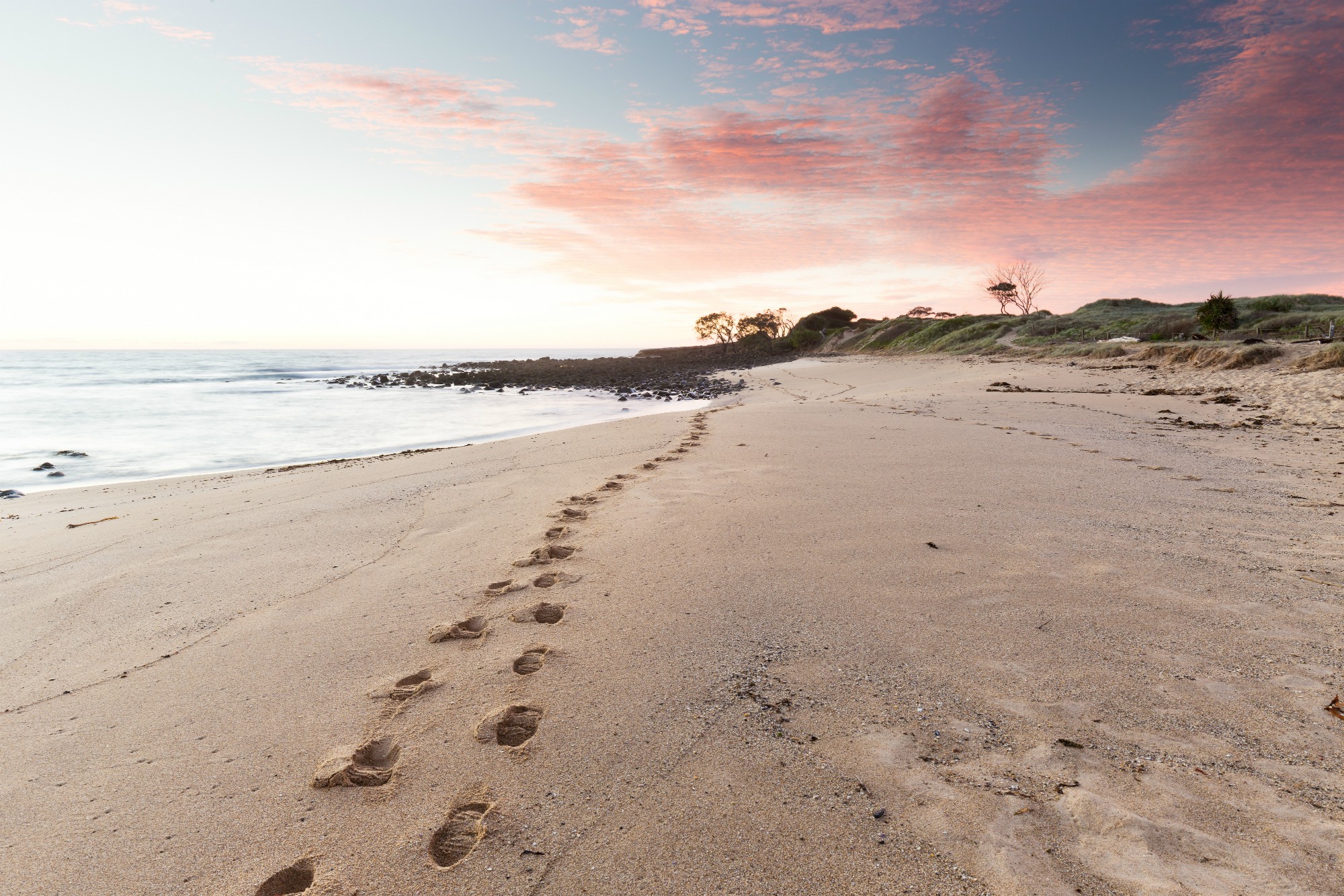 banner image of my footprints on a beach at sunset